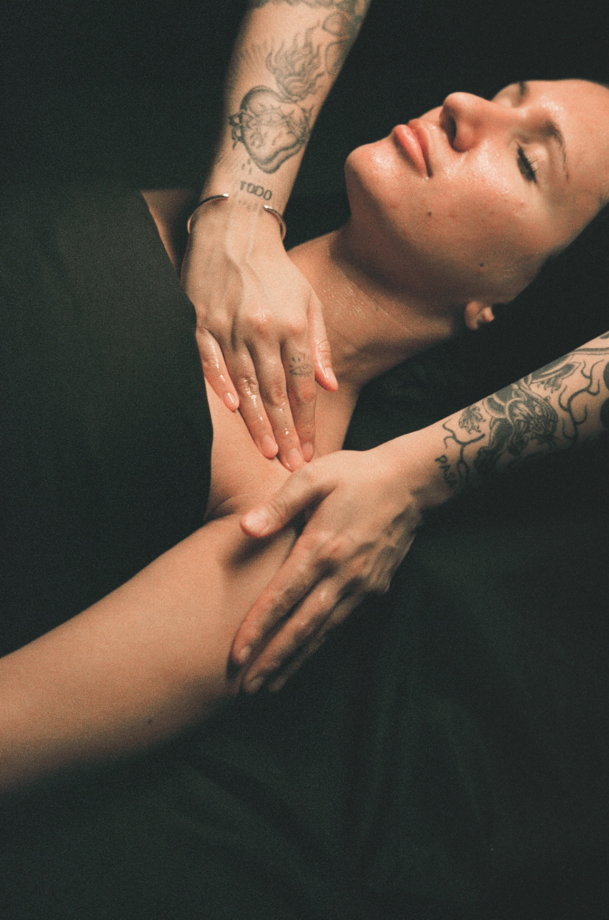 Esthetician's hands performing a slow, intentional face and neck massage on a relaxed client